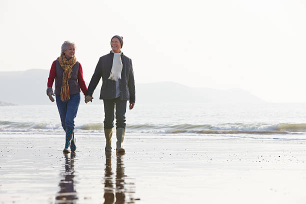 istock Senior Couple Walking Along Winter Beach 502702225