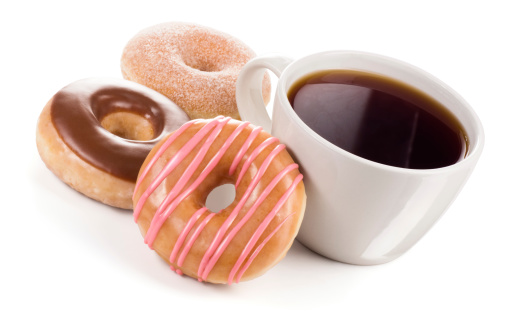 A large mug of black coffee (or tea) next to 3 different donuts on white.