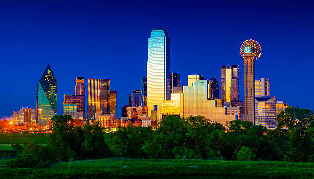 Downtown Dallas Cityscape Skyline Skyscrapers glowing at dusk / twilight The Dallas Skyline lighting up in vibrant colors just after sunset with an electric blue sky. reunion tower photos stock pictures, royalty-free photos & images