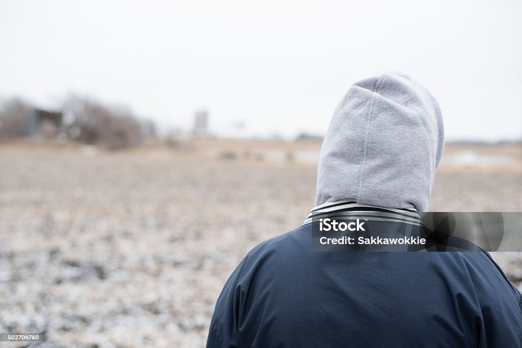 Anonymous Person With Hoodie Walking In Field Stock Photo