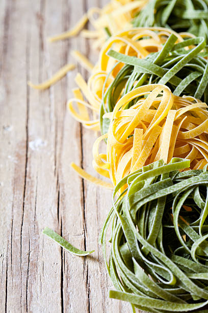 istock yellow and green uncooked pasta tagliatelle 502706535