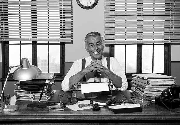 istock Smiling retro reporter working at office desk 502707362