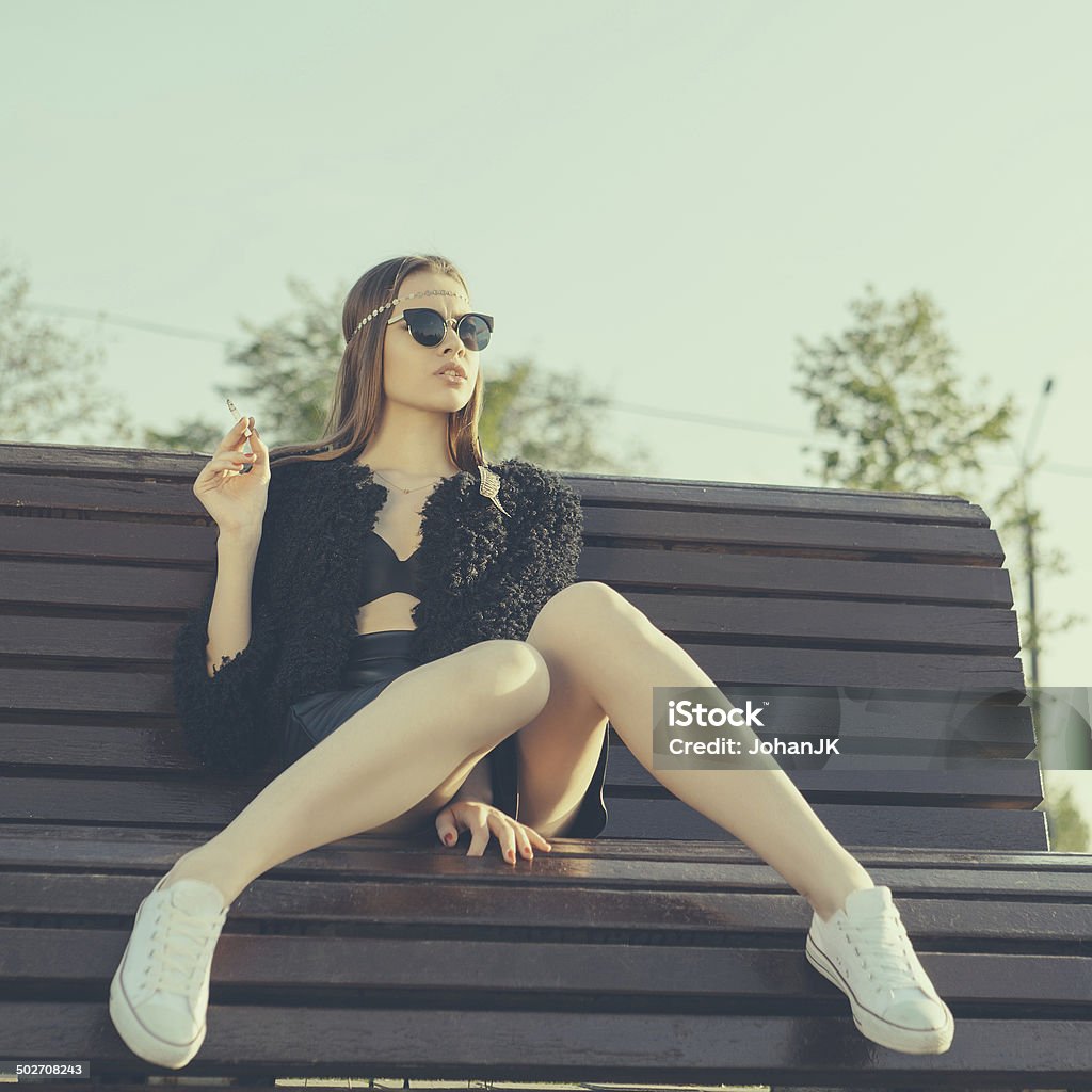 Young woman smoke in park Hipster girl smoke in park. Lifestyle outdoor portrait Adult Stock Photo