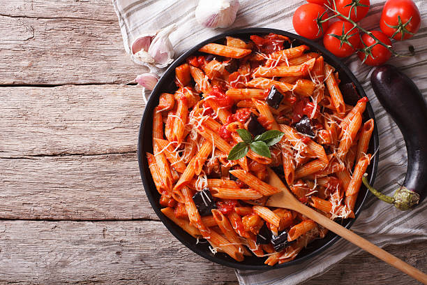 Italian Pasta alla Norma close-up and ingredients. horizontal to Italian food: Pasta alla Norma close-up on the table and ingredients. horizontal top view rigatoni stock pictures, royalty-free photos & images