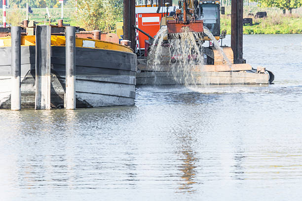 подводная выемка грунта в гавани раковина - industrial ship earth mover barge yellow стоковые фото и изображения