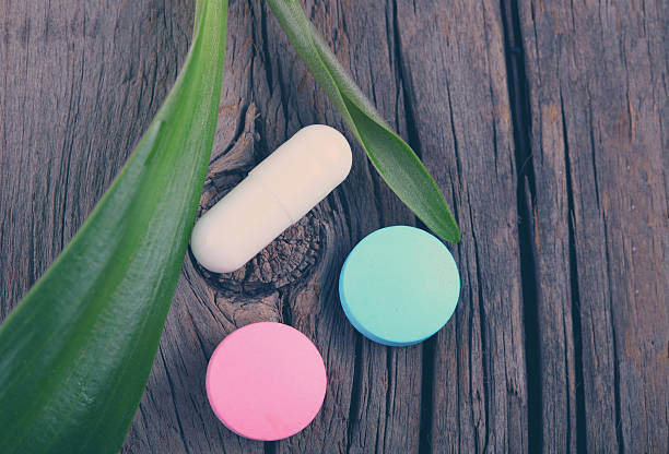 istock Capsules, tablet and plant on a wooden background 502709888