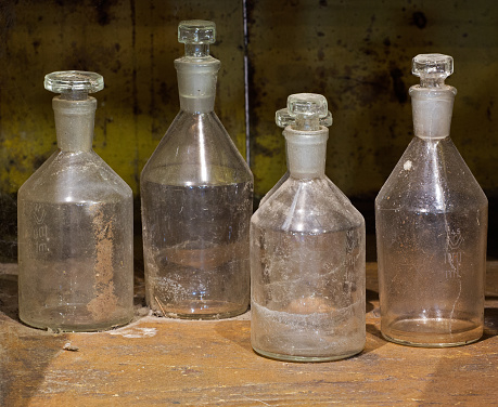 The old Reagent glass bottles on a dusty table