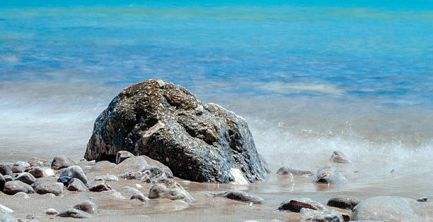 istock stone at the beach and silky water 502722697