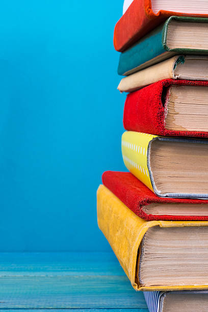 istock Stack of colorful hardback books, open book on blue background 502724964