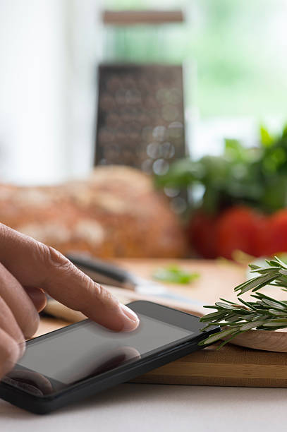 istock Cooking with a mobile phone with touching finger 502725727