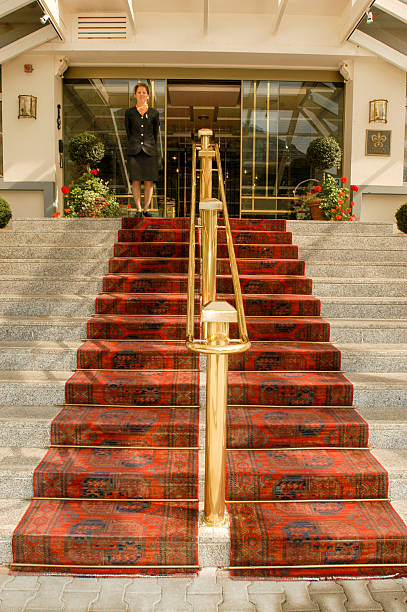 Receptionist waiting for customers at entrence of a hotel Leukerbad, Switzerland - 2 october 2002: receptionist waiting for customers at entrence of a hotel at Leukerbad on the Swiss alps entrence stock pictures, royalty-free photos & images