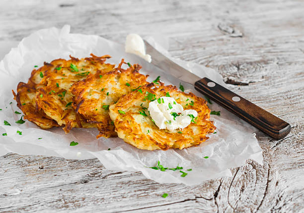 frittelle di patate o latkes su una superficie di legno rustico chiaro - latke foto e immagini stock