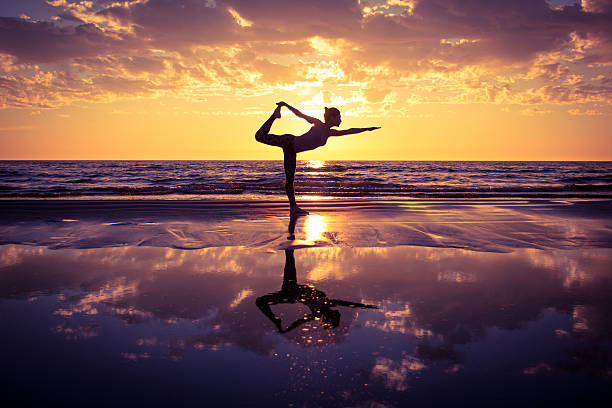 woman practicing yoga silhouette of woman practicing yoga on the beach at sunset meditating photos stock pictures, royalty-free photos & images