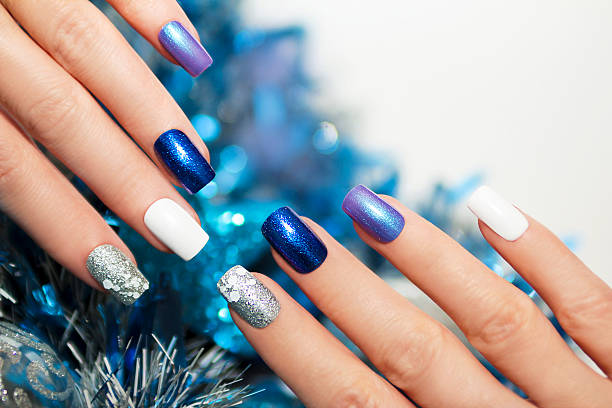 Christmas blue manicure. Christmas blue and silver with white nail Polish manicure. christmas nails stock pictures, royalty-free photos & images