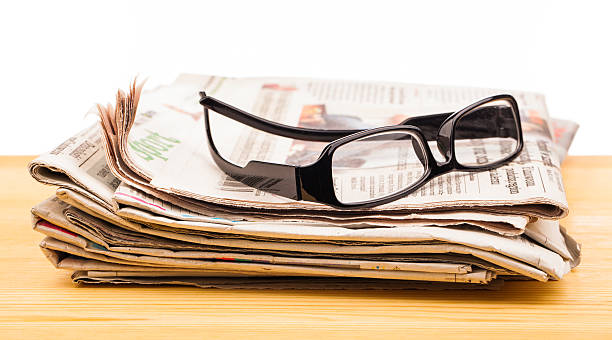 istock pile of newspapers and reading glasses 502732796