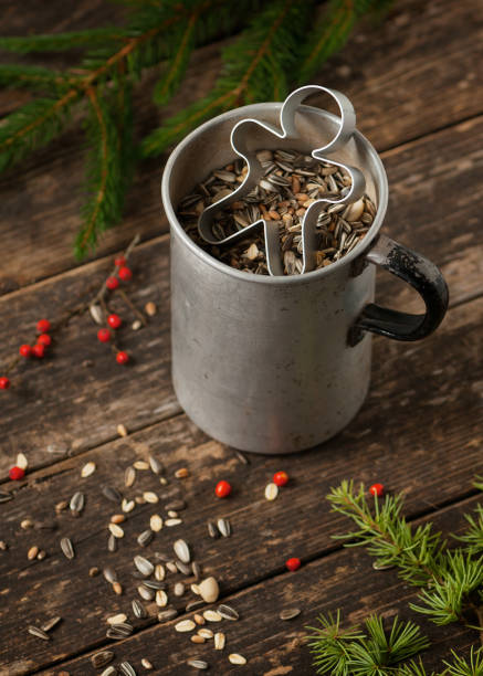 Preparation of gingerbread man bird food suet cookies. Preparation of gingerbread man bird food suet cookies. Cup with mixed birdseed.  palmin photos stock pictures, royalty-free photos & images