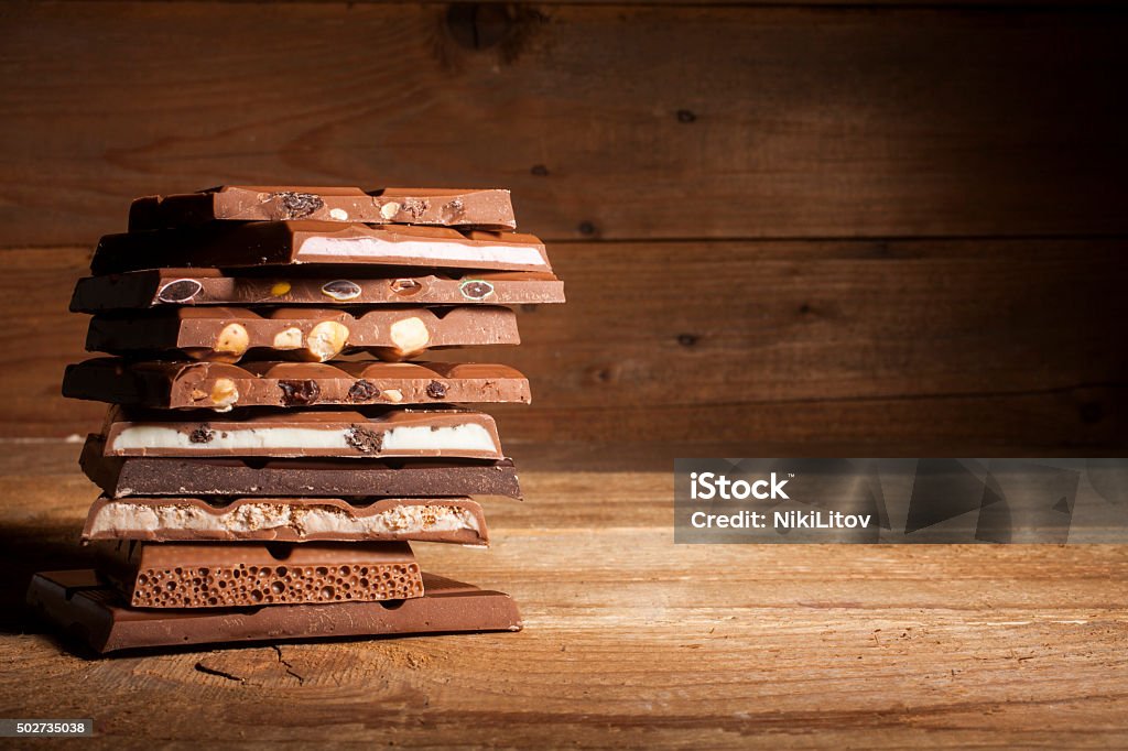 Chocolate stack on wooden background Chocolate blocks stack with different kind of chocolate on wooden background  Chocolate Stock Photo