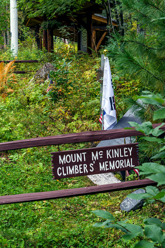 Talkeetna, Alaska, USA. August 29, 2015. A sign dedicated to the dead mountain climbers of Mt. McKinley (Denali) with a flag and stone marking the memorial. 