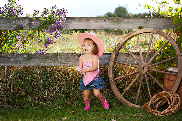 Little Cowgirl Adorable toddler dressed as a cowgirl. baby gun stock pictures, royalty-free photos & images
