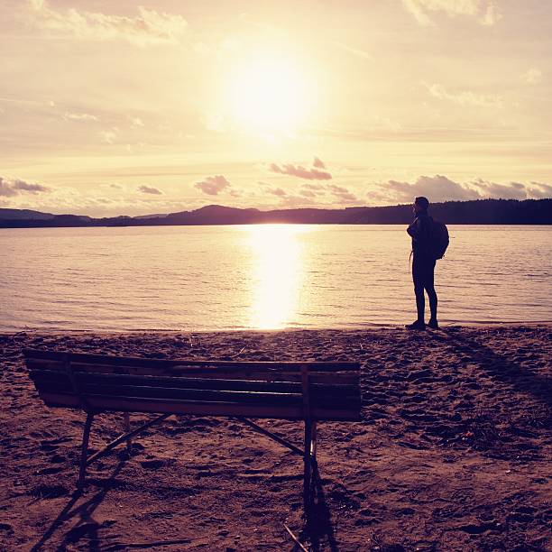 istock Alone traveler with backpack. Man  on sea beach at bench 502738732