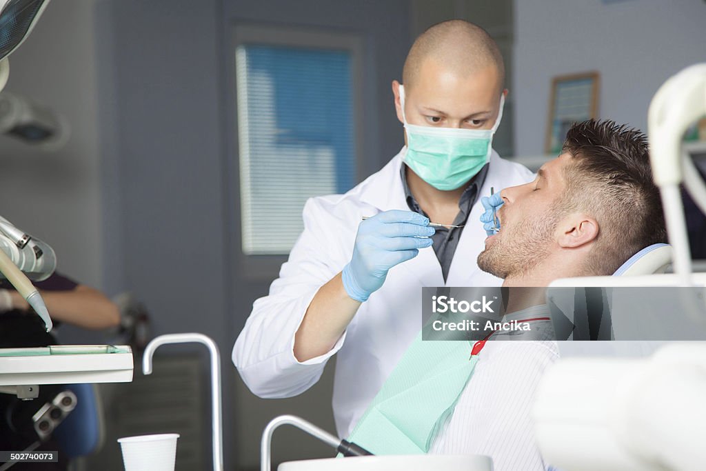 Dentist Female dentist with male patient Adult Stock Photo
