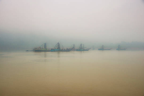 Dredgers on the Yangtze River China.  Dredgers on the mighty Yangtze river. One of the many heavy polluted regions upstream the Three Gorges Dam. yangtze river stock pictures, royalty-free photos & images