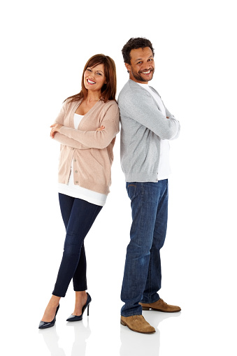 Studio shot of smiling mature couple standing back to back  on white background