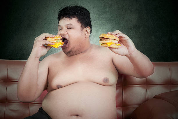 'greedy'gordura homem comer hambúrguer 3 - remote fat overweight dieting imagens e fotografias de stock