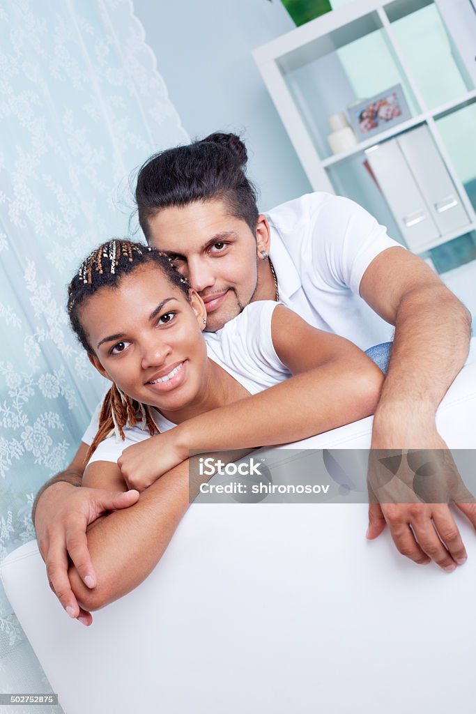 Young couple Image of young guy and his girlfriend looking at camera while relaxing at home Adult Stock Photo
