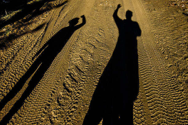 Adult and child silhouettes in a country road vote for something.