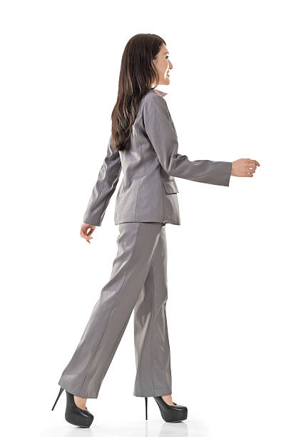 Happy businesswoman holding briefcase and putting her hand on hip on white background