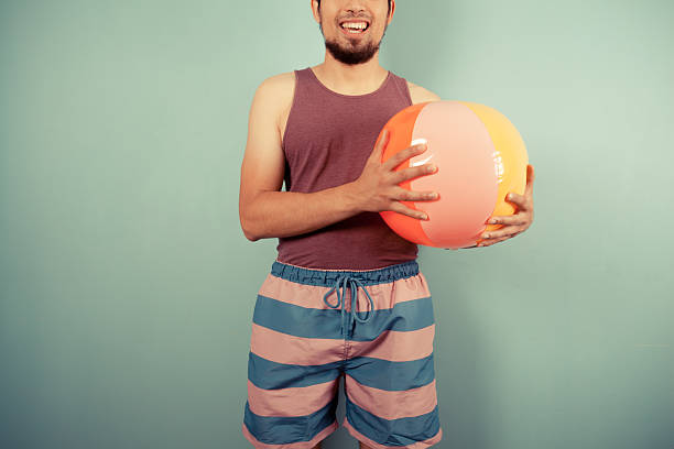 istock Happy young man with a beach ball 502759179