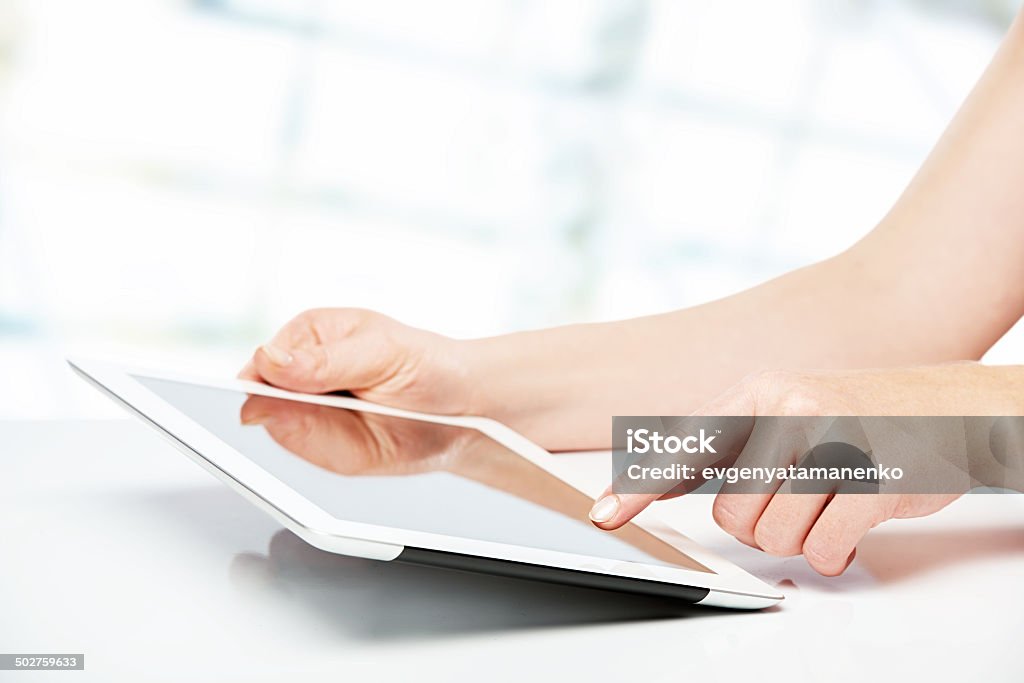 white tablet with   blank screen in the hands on table white tablet with a  blank screen in the hands on wooden table Digital Tablet Stock Photo