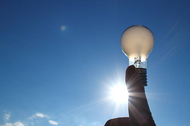 istock white bulb and the forefinger in the sunlight 502761528