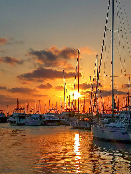 istock Sailing ships in port at sunset with red sky 502778568