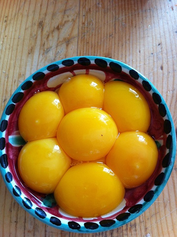 Bowl with seven yolks on a wooden table