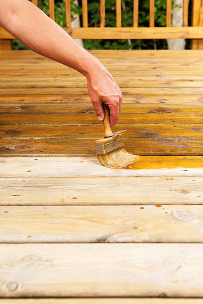 istock Hand Applying Deck Stain with a Large Paintbrush 502788163