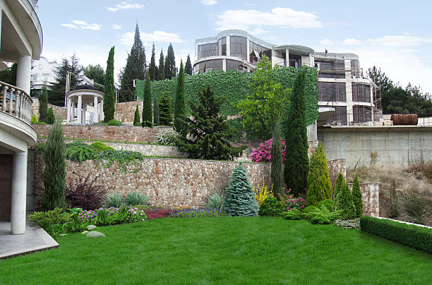 террасовое ландшафта, встроенные в естественной среде. - retaining wall flower bed ornamental garden landscaped стоковые фото и изображения