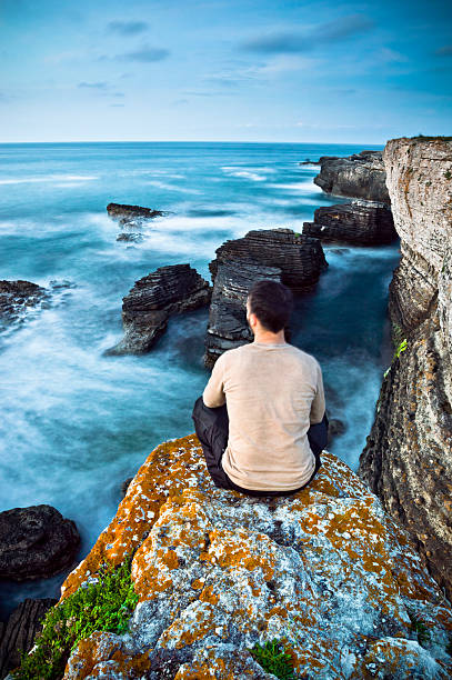 istock Man Sitting on Top of Rock 502790881