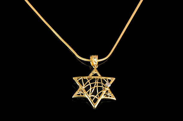 istock Star of David gold pendant on black reflective background 502791099