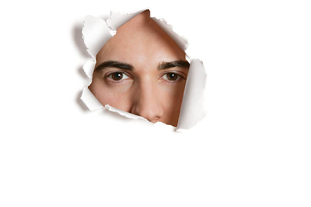 istock Person peeking through torn hole 502791615