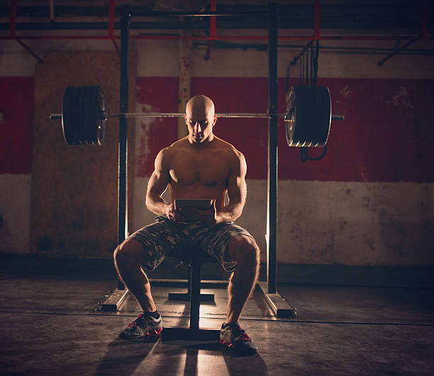 istock Muscular man uses tablet in the gym 502804934