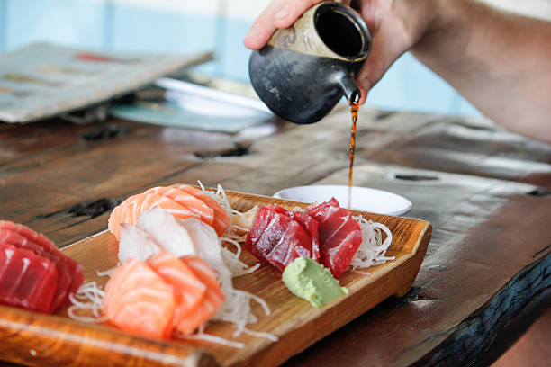 Male hands pouring soy sauce