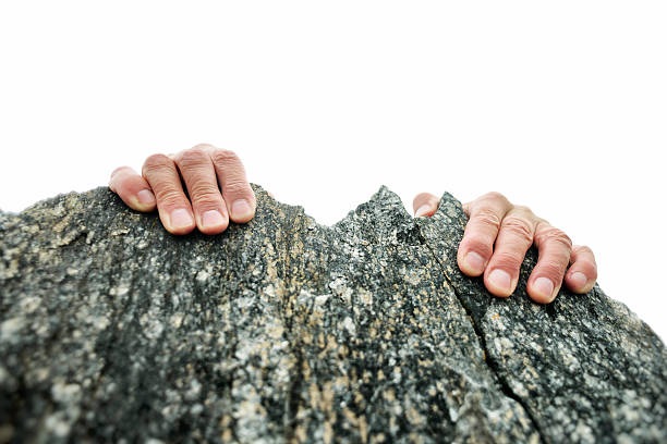Hands Gripping the Rock Summit stock photo