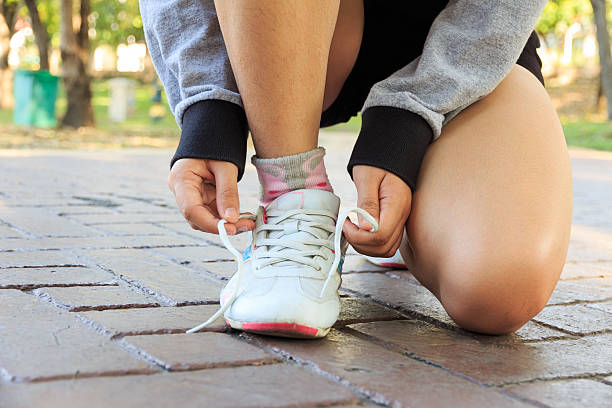 istock Female athlete tying laces for jogging on road 502809684