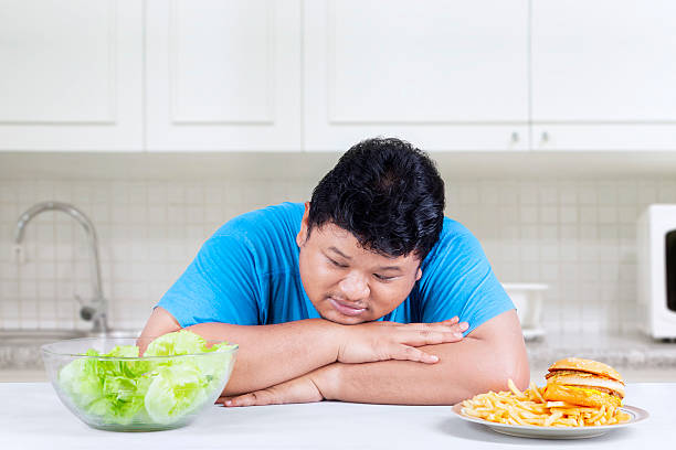 istock Obese man looking at salad 1 502814787