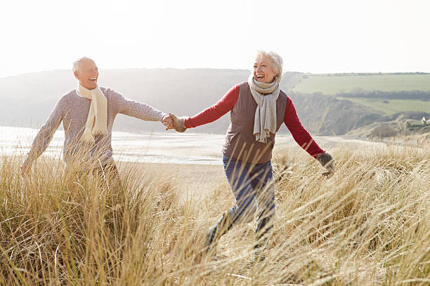 istock Senior Couple Walking Through Sand Dunes On Winter Beach 502814881