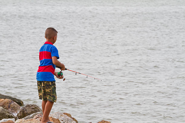 istock boy fishing at thai sea 502816087