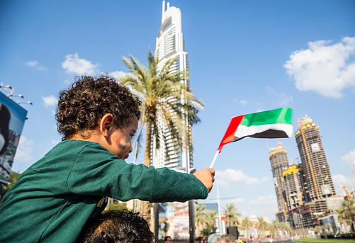 Dubai, United Arab Emirates, November 28, 2015: Boy holding a United Arab Emirates flag