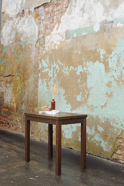 istock Wooden table with vase and wallnuts near old plastered wall 502816678